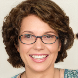 Joyful white adult female with medium  brown hair and blue eyes