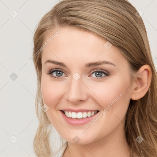 Joyful white young-adult female with long  brown hair and blue eyes