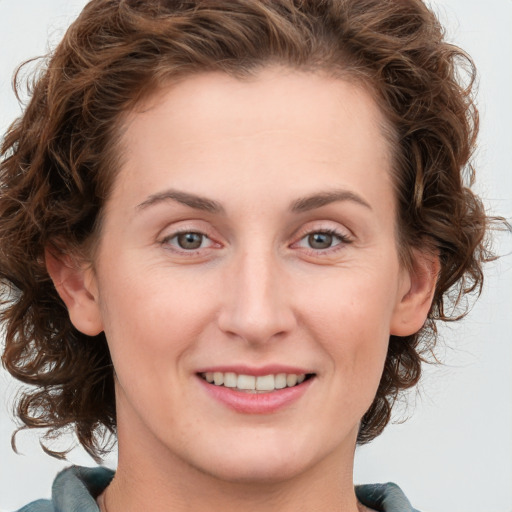 Joyful white young-adult female with medium  brown hair and green eyes