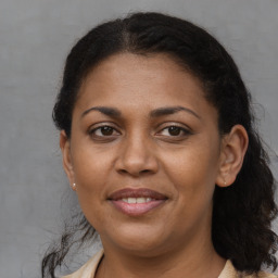 Joyful black adult female with long  brown hair and brown eyes