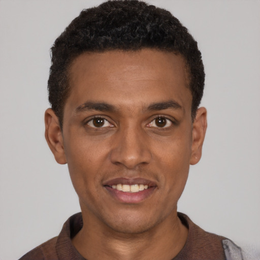 Joyful black young-adult male with short  black hair and brown eyes
