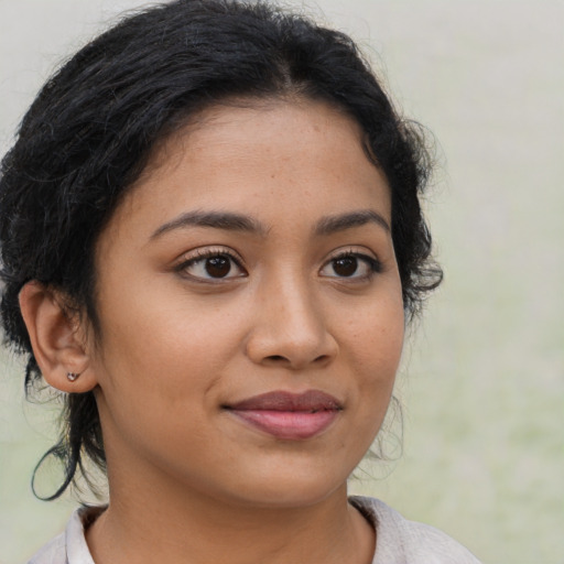 Joyful latino young-adult female with medium  brown hair and brown eyes