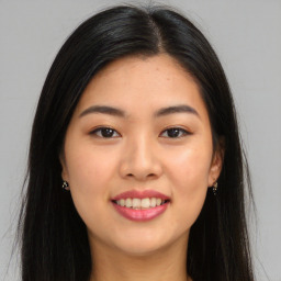 Joyful asian young-adult female with long  brown hair and brown eyes