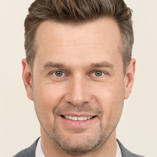 Joyful white adult male with short  brown hair and grey eyes