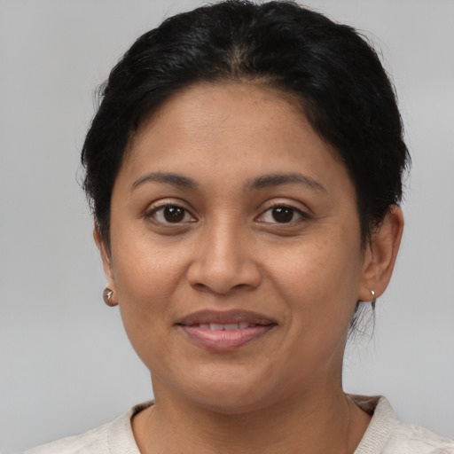 Joyful latino adult female with short  brown hair and brown eyes