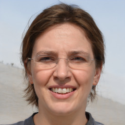 Joyful white adult female with medium  brown hair and blue eyes