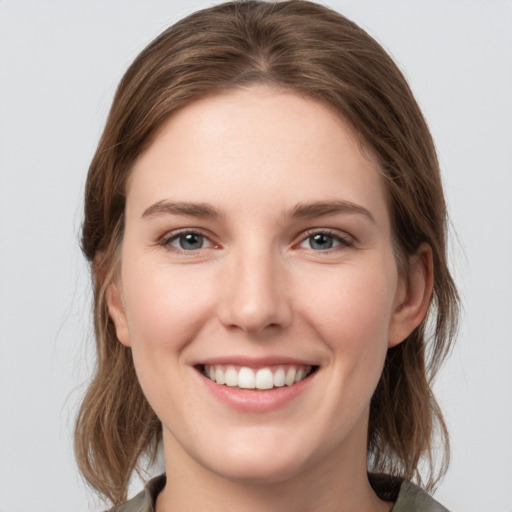 Joyful white young-adult female with medium  brown hair and grey eyes