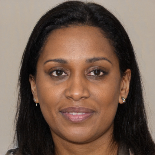 Joyful black young-adult female with long  brown hair and brown eyes