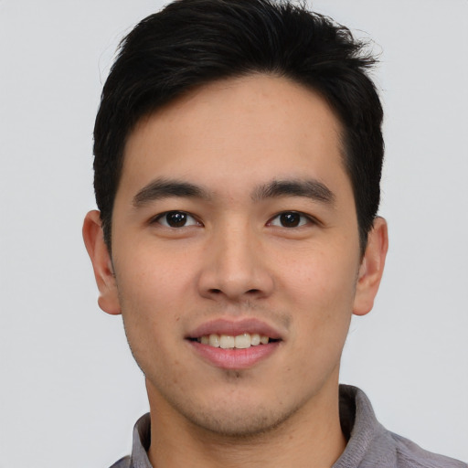 Joyful asian young-adult male with short  brown hair and brown eyes