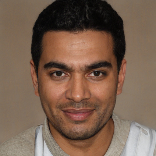 Joyful latino young-adult male with short  black hair and brown eyes