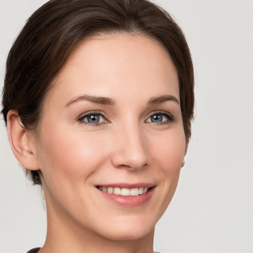 Joyful white young-adult female with short  brown hair and grey eyes