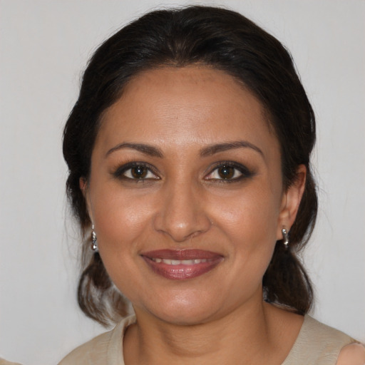 Joyful black adult female with medium  brown hair and brown eyes