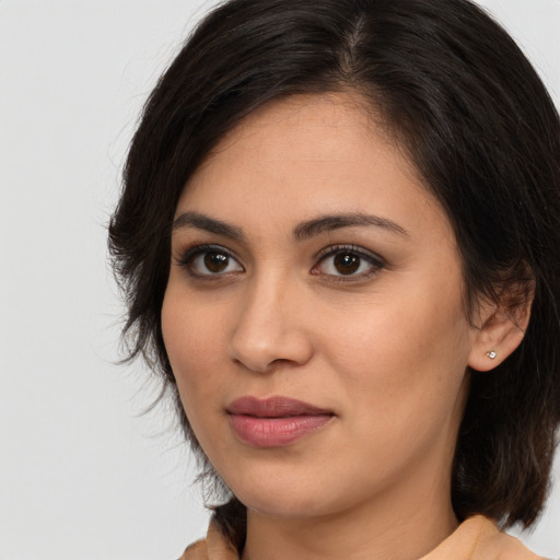Joyful latino young-adult female with medium  brown hair and brown eyes