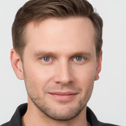 Joyful white young-adult male with short  brown hair and grey eyes