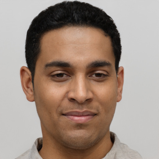Joyful latino young-adult male with short  black hair and brown eyes