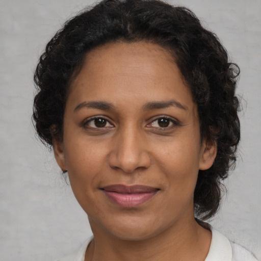 Joyful black adult female with medium  brown hair and brown eyes