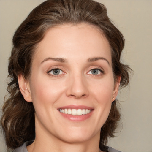 Joyful white young-adult female with medium  brown hair and blue eyes