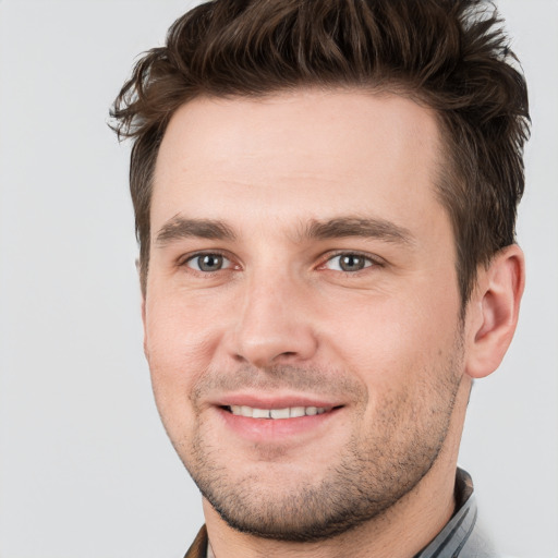 Joyful white young-adult male with short  brown hair and grey eyes