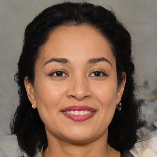 Joyful latino young-adult female with medium  brown hair and brown eyes