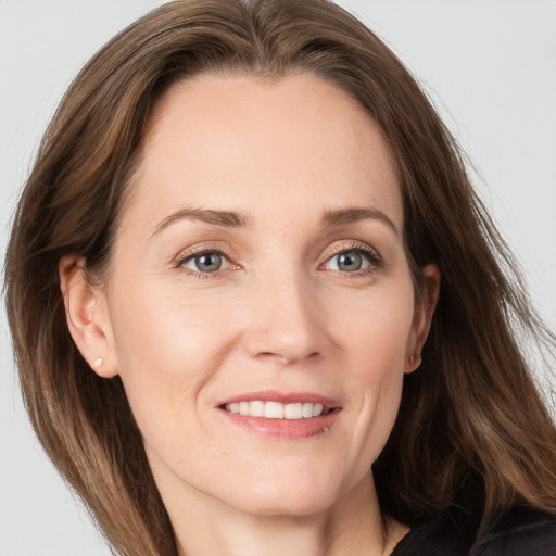 Joyful white adult female with long  brown hair and grey eyes