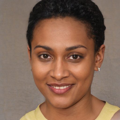 Joyful black young-adult female with short  brown hair and brown eyes