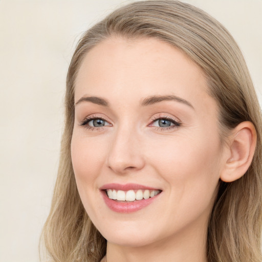 Joyful white young-adult female with long  brown hair and blue eyes