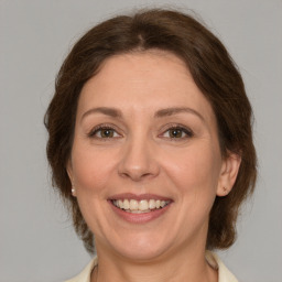 Joyful white adult female with medium  brown hair and green eyes