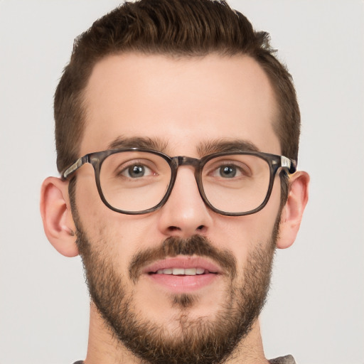 Joyful white young-adult male with short  brown hair and green eyes