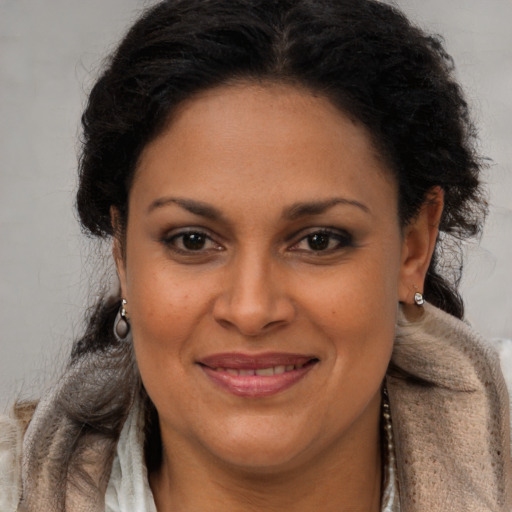 Joyful latino adult female with long  brown hair and brown eyes