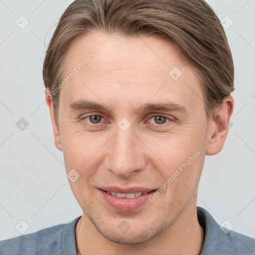 Joyful white young-adult male with short  brown hair and grey eyes