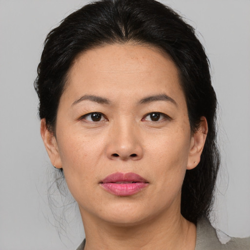 Joyful asian adult female with medium  brown hair and brown eyes