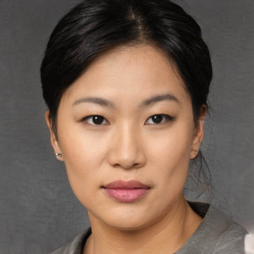 Joyful asian young-adult female with medium  black hair and brown eyes