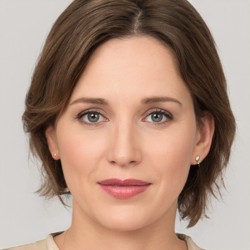 Joyful white young-adult female with medium  brown hair and grey eyes