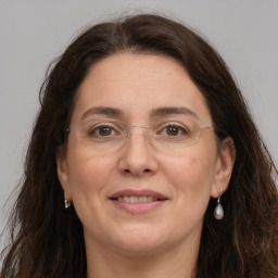 Joyful white adult female with long  brown hair and grey eyes