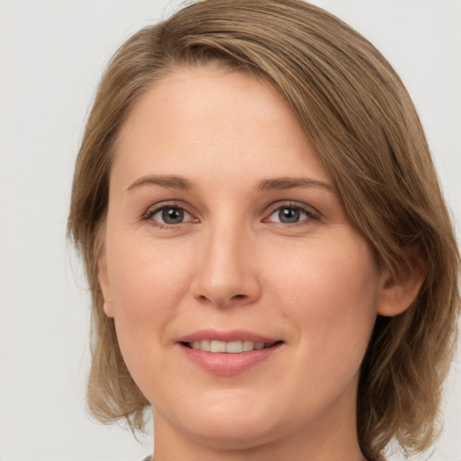 Joyful white young-adult female with medium  brown hair and green eyes