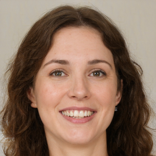 Joyful white adult female with long  brown hair and green eyes