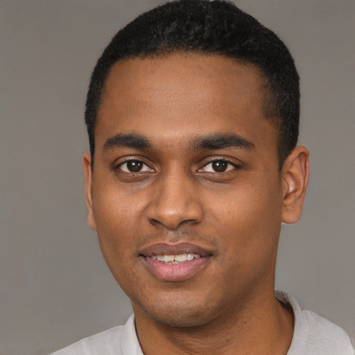 Joyful black young-adult male with short  black hair and brown eyes