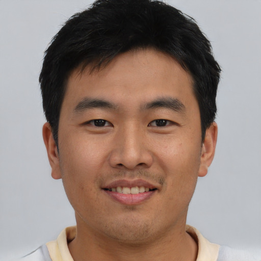 Joyful asian young-adult male with short  black hair and brown eyes