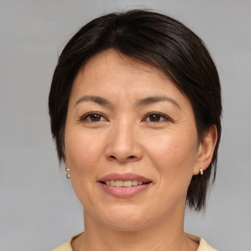 Joyful asian adult female with medium  brown hair and brown eyes