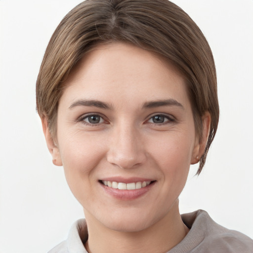 Joyful white young-adult female with short  brown hair and grey eyes