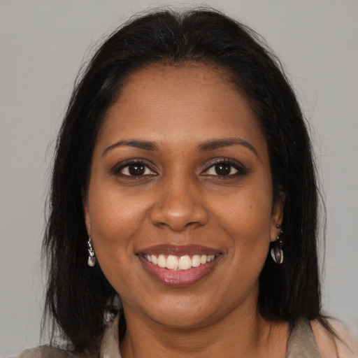 Joyful black young-adult female with medium  brown hair and brown eyes