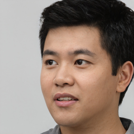 Joyful asian young-adult male with short  black hair and brown eyes