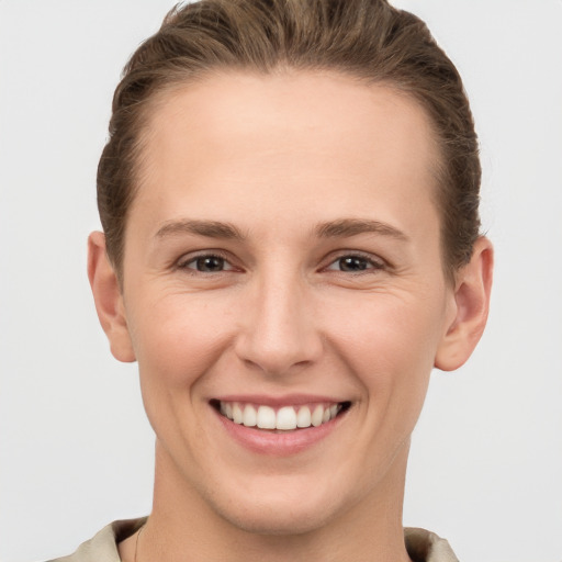 Joyful white young-adult female with short  brown hair and grey eyes