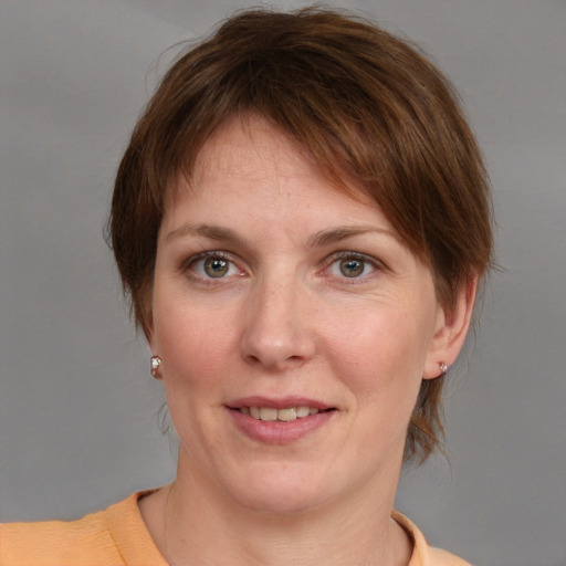 Joyful white young-adult female with medium  brown hair and grey eyes