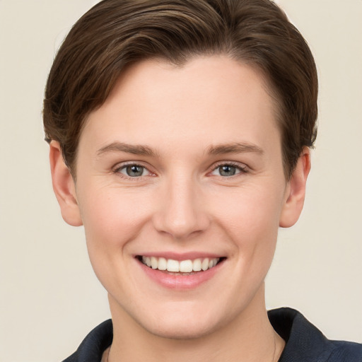 Joyful white young-adult female with short  brown hair and grey eyes