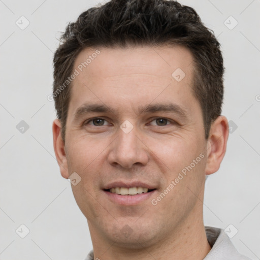 Joyful white young-adult male with short  brown hair and grey eyes