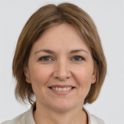 Joyful white adult female with medium  brown hair and grey eyes