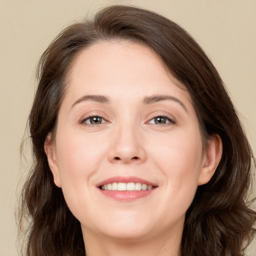 Joyful white young-adult female with long  brown hair and grey eyes