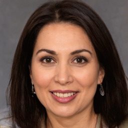 Joyful white adult female with long  brown hair and brown eyes