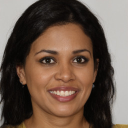 Joyful black young-adult female with long  brown hair and brown eyes